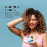 Woman with curly hair holding a product container against a blue background