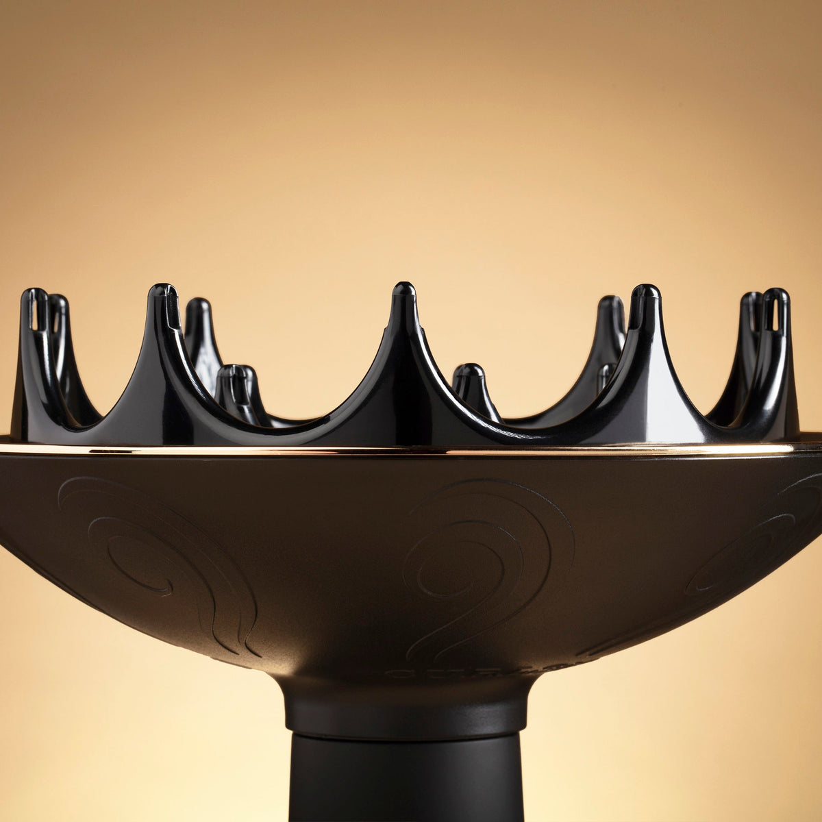 Black hair dryer nozzle on a beige background